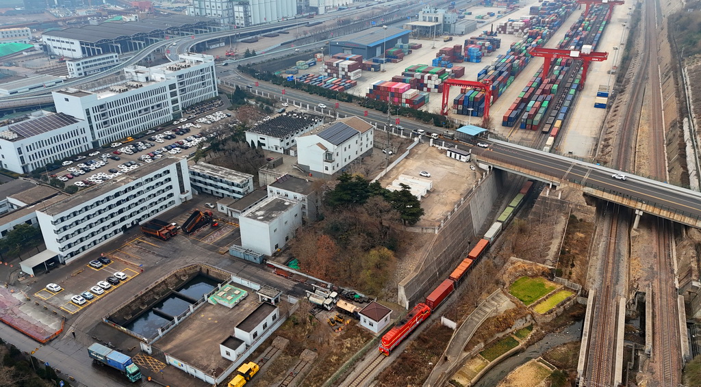 1月2日，在中哈（连云港）物流合作基地，一列中欧班列缓缓驶出（无人机照片）。新华社发（耿玉和摄）