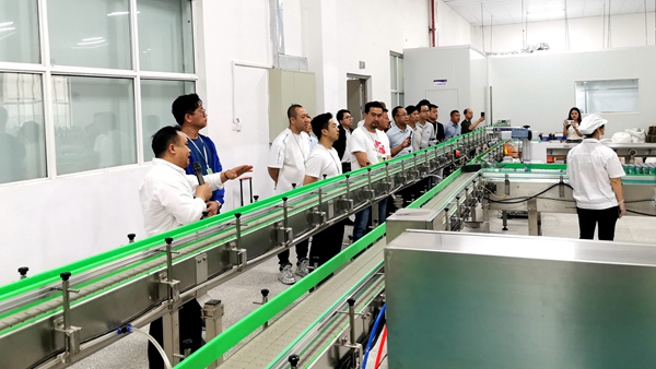 图为采购团调研林管家食品科技有限公司的糯玉米产品生产情况