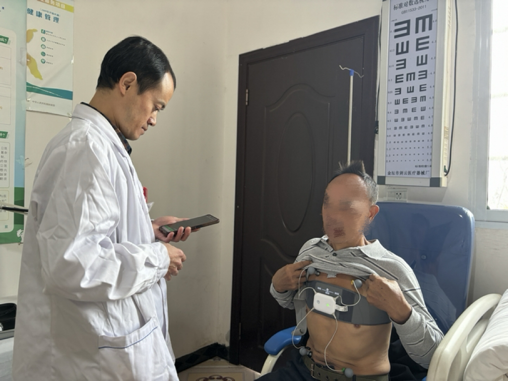 桐梓村民正在村卫生室通过穿戴式心电图机进行检查。王洪娅摄