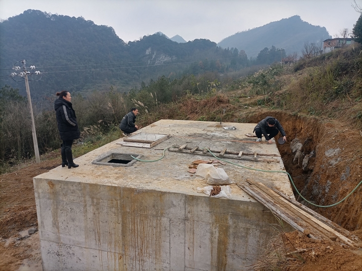 工作人员现场测量蓄水池尺寸。