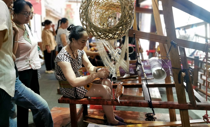 图为学徒们在用心观摩织娘操作